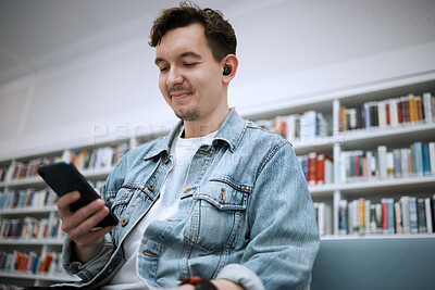 Buy stock photo Library, man and smartphone for typing, music and relax on weekend, student and connection for social media. Male, gentleman and guy with cellphone, listening to audio and podcast with smile and joy