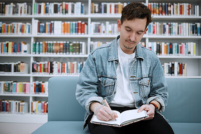 Buy stock photo College student man, library and writing on sofa with ideas, vision and focus on education at academy lounge. University, pen and notebook for notes, goals and studying for exam, research and task