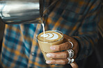 Latte art, coffee and barista hand with process, workflow and production with drink and working in cafe. Creative, man drawing with milk foam and hospitality with service and beverage closeup