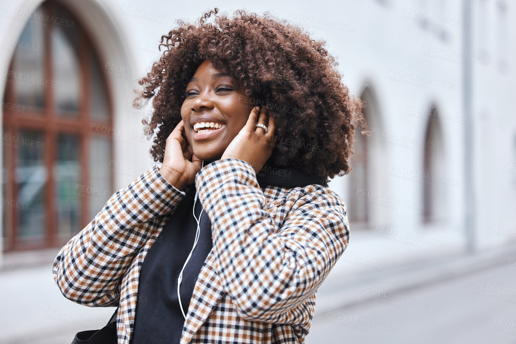 Buy stock photo Black woman, earphones and listening to music in the city streets with smile for entertainment. Happy African American female walking in a urban town smiling in joyful happiness for audio sound track