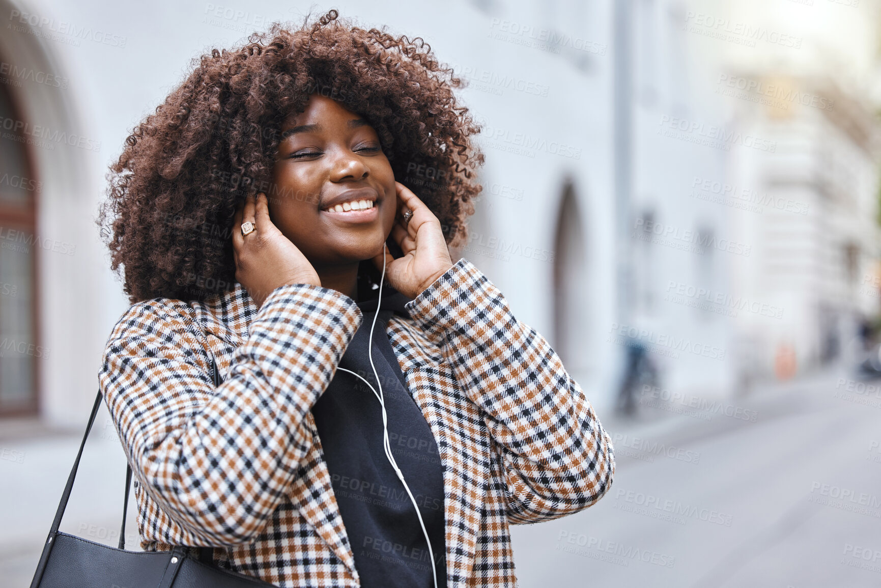 Buy stock photo Happy, city and black woman listening to music, radio or song in the street while walking to work. Happiness, smile and African female streaming a playlist, album or audio with earphones in the road.