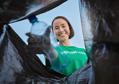 Buy stock photo Recycle, bottle and asian woman with view in bag, sustainability and cleaning plastic pollution, earth day and help with community. Saving the environment, charity and people putting trash in garbage