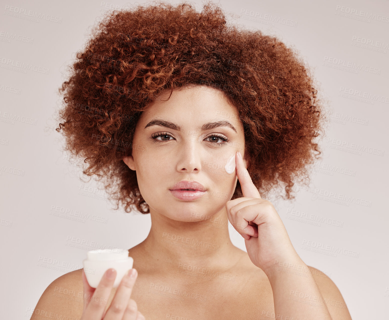 Buy stock photo Skincare, beauty and portrait of black woman with lotion on face, afro and advertising luxury skin product promotion. Dermatology, cosmetics and facial, model with jar isolated on studio background.