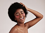 Skincare, beauty and black woman with collagen eye patches for anti ageing treatment isolated on grey background. Health, skin and model with afro, smile and face mask on eyes, spa facial in studio.