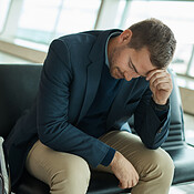 Airport, sad and headache of man waiting to travel, frustrated or ...
