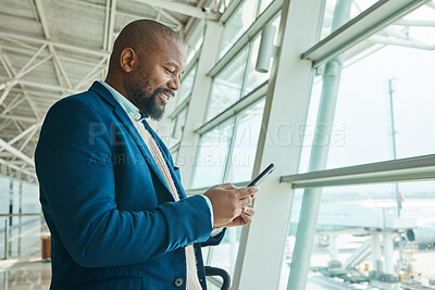 Buy stock photo Black man, phone and chatting at airport for business travel, trip or communication waiting for flight. African American male smile for conversation, schedule or checking plain times on smartphone