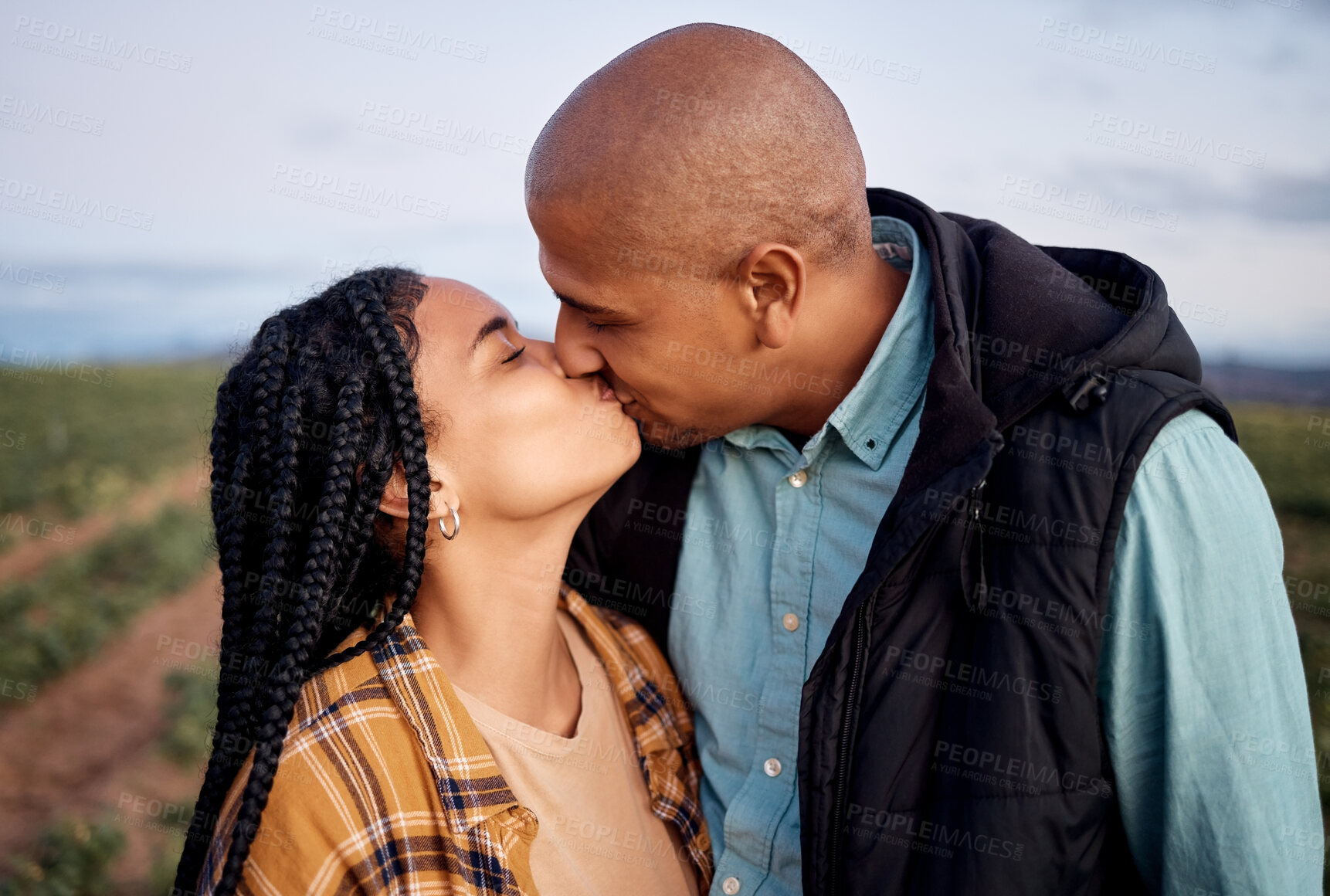 Buy stock photo Agriculture, sustainability and a couple kissing on a farm outdoor for growth in nature during the harvest season. Love, summer or farming with a man and woman sharing a kiss in the countryside