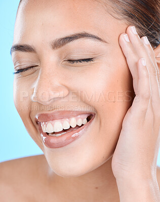 Buy stock photo Happy, skincare and smile by woman in studio for makeup, wellness and cosmetics grooming on blue background, Face, beauty and girl model relax, laughing and excited for facial product or treatment