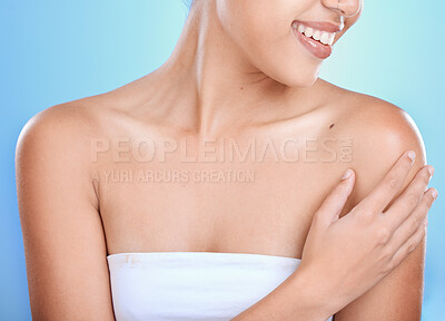 Buy stock photo Woman, hands and smile for skincare, cosmetics or spa treatment against a blue studio background. Hand of happy female touching shoulder and smiling in beauty for soft smooth skin, self love or care