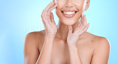 Buy stock photo Hand, face and touching skin with a model woman in studio on a blue background for beauty or skincare. Hands, touch and facial with a young female indoor to promote an antiaging cosmetic product