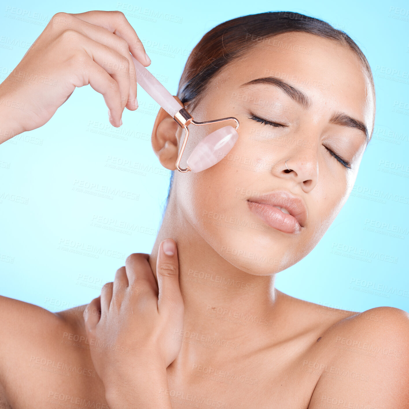 Buy stock photo Skincare, rose quartz and face massage in studio for beauty, anti aging and skin wellness on blue background. Facial, derma roller and girl model relax with luxury, skin and product while isolated 