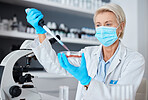 Woman, doctor and pipette with mask and gloves for safety experiment, sample or testing in scientific research at lab. Female scientist or medical expert working with chemicals in science laboratory