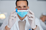 Man, doctor and hands with blood sample, vial or tube for scientific research, testing or exam in lab. Male scientist or medical expert with mask and gloves holding DNA for science test at laboratory