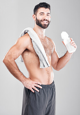 Buy stock photo Portrait, exercise and man with towel, water bottle and training on grey studio background. Canada, face and happy male athlete with liquid after practice, healthy lifestyle and workout for wellness