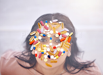 Addiction, pills and medicine on woman face as drug abuse from overhead view looking serious and covered by medication. Tablets, issue and antibiotics problem by mental health patient or female