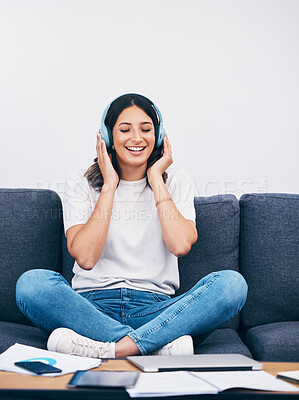 Buy stock photo Music, relax and break with a woman in her home, listening to the radio while sitting on the living room sofa. Peace, wellness or headphones with an attractive young female streaming audio in a house