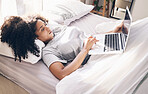 Music earphones, woman and laptop in bed in bedroom for social media or internet browsing in the morning. Technology, relax or black female with computer for streaming podcast, audio or radio in home