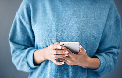 Buy stock photo Phone, hands and woman texting in studio for internet, search or social media on grey background. Online, communication and girl searching on smartphone, website or app while reading isolated closeup