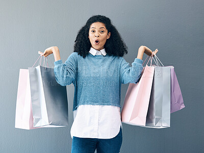 Buy stock photo Wow, sale and portrait of woman with shopping bags, retail therapy and surprise at gift on a wall. Deal, excited and happy girl holding products from a shop, market or mall on a grey background