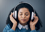 Headphones, music and face of black woman relax with wall background listening to audio, radio and song. Freedom, calm and happy girl in studio for peace, mindset and streaming wellness podcast