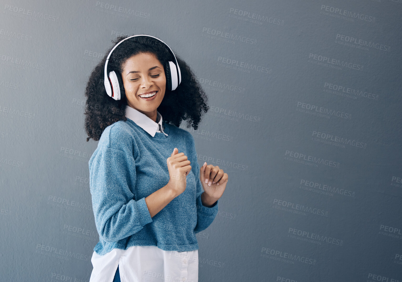 Buy stock photo Dance, music and black woman in studio with freedom, streaming or good mood on grey background. Radio, podcast and girl relax while dancing to audio, online and playlist on advertising isolated space