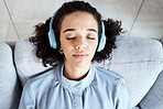 Woman, face and headphones for listening to music for calm, peace and mindfulness on home couch. Young person on living room sofa listen to podcast, audio or motivation to relax or meditation above