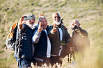 Senior hiking, mountain selfie and elderly friends in nature on a walk with freedom in retirement. Healthy exercise, trekking and and outdoor adventure of old men group together with peace sign