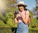 Photography, tourism and woman with a camera in nature for travel memory in Sweden. Summer, tourist and photographer looking at photos while traveling on a vacation in a park or botanical garden