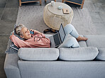 Laptop, phone call and senior woman on a sofa with a remote job working on a project at her home. Happy, laugh and elderly female on a mobile conversation while on a computer in her living room.