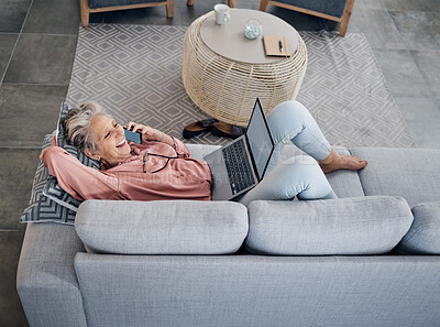 Buy stock photo Laptop, phone call and senior woman on a sofa with a remote job working on a project at her home. Happy, laugh and elderly female on a mobile conversation while on a computer in her living room.