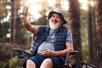 Buy stock photo Camping, old man and in forest with coffee, smile and fresh air with break, vacation and relax. Camper, mature male and elderly guy with mug, tea and in woods for hobby, happiness and active citizen