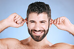 Cleaning, ear and man with cotton bud in studio for hygiene, grooming and beauty routine on blue background. Earwax, product and guy model in cosmetic, luxury and wax, removal or stick while isolated