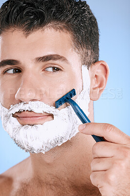 Buy stock photo Shaving, beard and cosmetic man with cream for grooming isolated on a blue background. Skincare, beauty and model with razor to shave hair on face with foam for a clean facial look on a backdrop