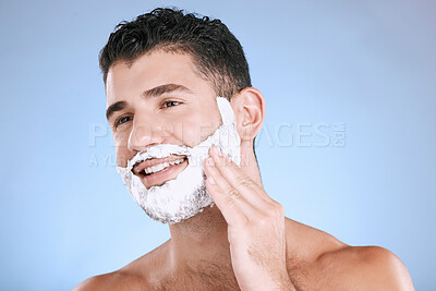 Buy stock photo Shaving, foam on beard and man with smile and hand on face, product placement and mock up in studio. Shave cream, hair and skincare for happy male model facial grooming, isolated on blue background.