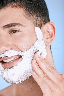 Buy stock photo Shaving, foam and smile on face, man with hand on beard, product placement and mock up in studio. Shave cream facial, luxury hair and skincare for male model with smile, isolated on blue background.