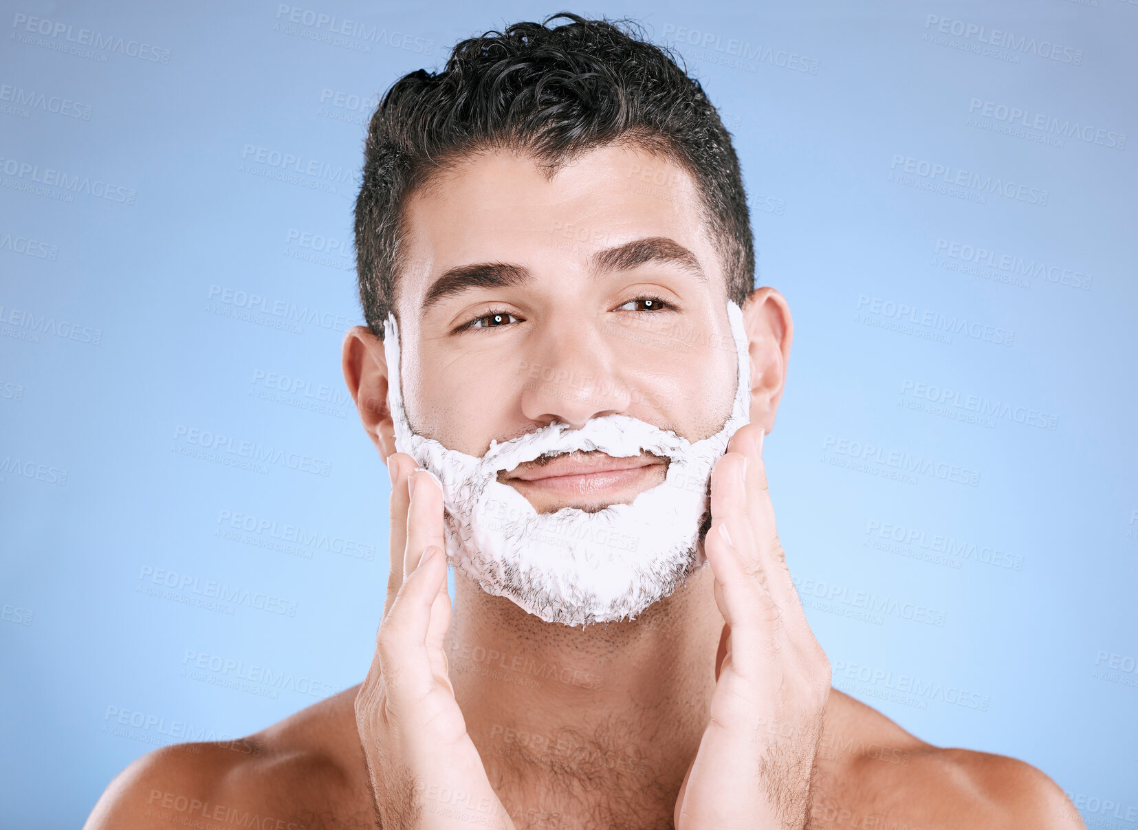 Buy stock photo Shaving, foam on beard and man with hands on face, smile and product placement in studio mock up. Shave cream facial, hair and skincare for happy male model grooming, isolated on blue background.