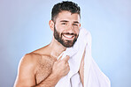 Man, face and shower with hygiene, towel and beauty in portrait, smile and grooming in studio. Skincare, cosmetics and clean face with healthy skin, mockup and cosmetic care on blue background