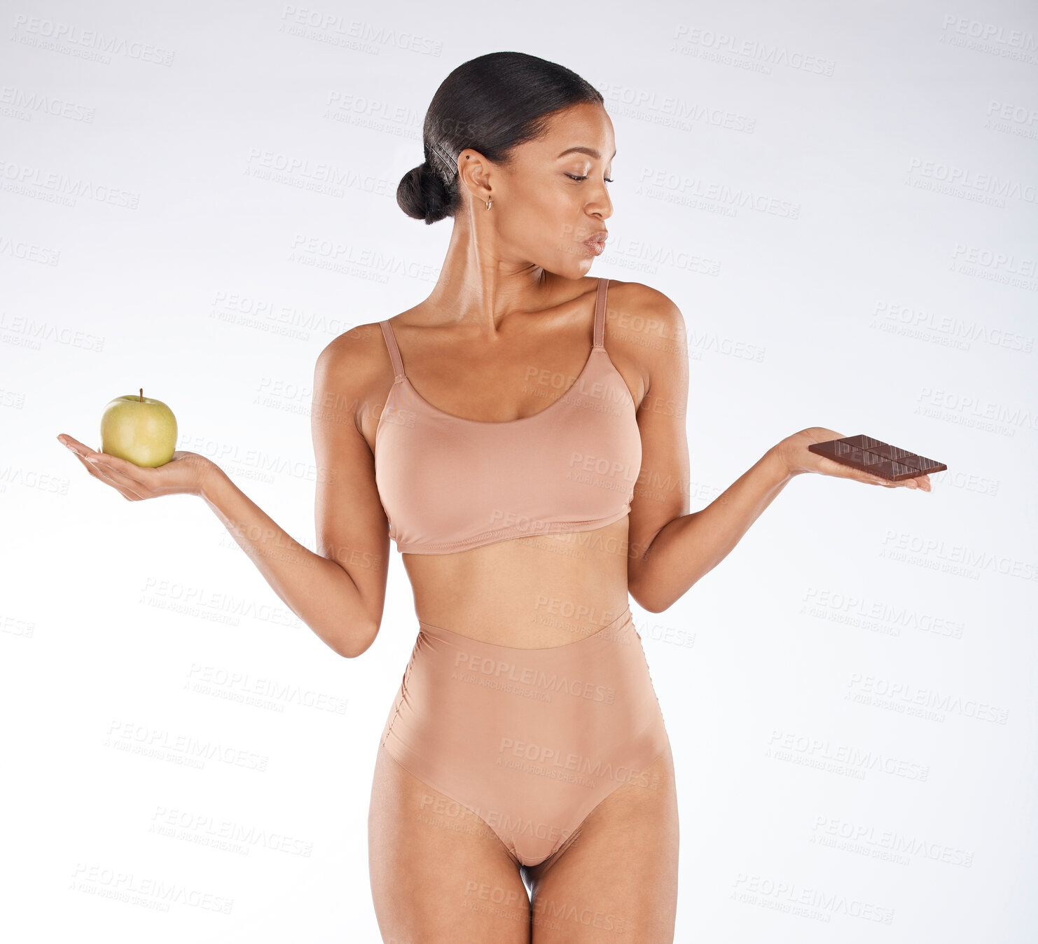 Buy stock photo Black woman, studio and choice for chocolate, apple and health for weight loss, body or nutrition by background. Gen z model, underwear or decision for diet, fruit or candy for thinking of cheat day