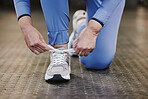 Sports, hands and tie shoes in gym to start workout, training or exercise for wellness. Fitness, athlete health or senior woman tying sneakers or footwear laces to get ready for exercising or running