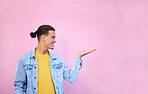 Happy, hand and of a man in a studio with mockup space for advertisement, product placement or marketing. Happiness, smile and male model showing mock up or copyspace isolated by a pink background.