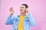 Headphones, man and happy dance on pink background, wall backdrop or studio mockup. Excited guy listening to music, sound and streaming audio media with freedom, smile and hearing radio for dancing 