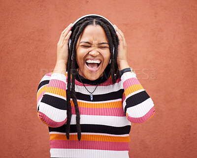 Buy stock photo Loud music, headphones and black woman isolated on orange wall singing, wow and excited for gen z subscription. African person or happy youth listening to 5g audio technology or streaming services