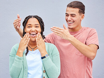 Buy stock photo Wow, surprise or love and a couple on a gray background outdoor with a man covering the eyes of his girlfriend. Diversity, hands or dating with a woman being surprised by her boyfriend against a wall