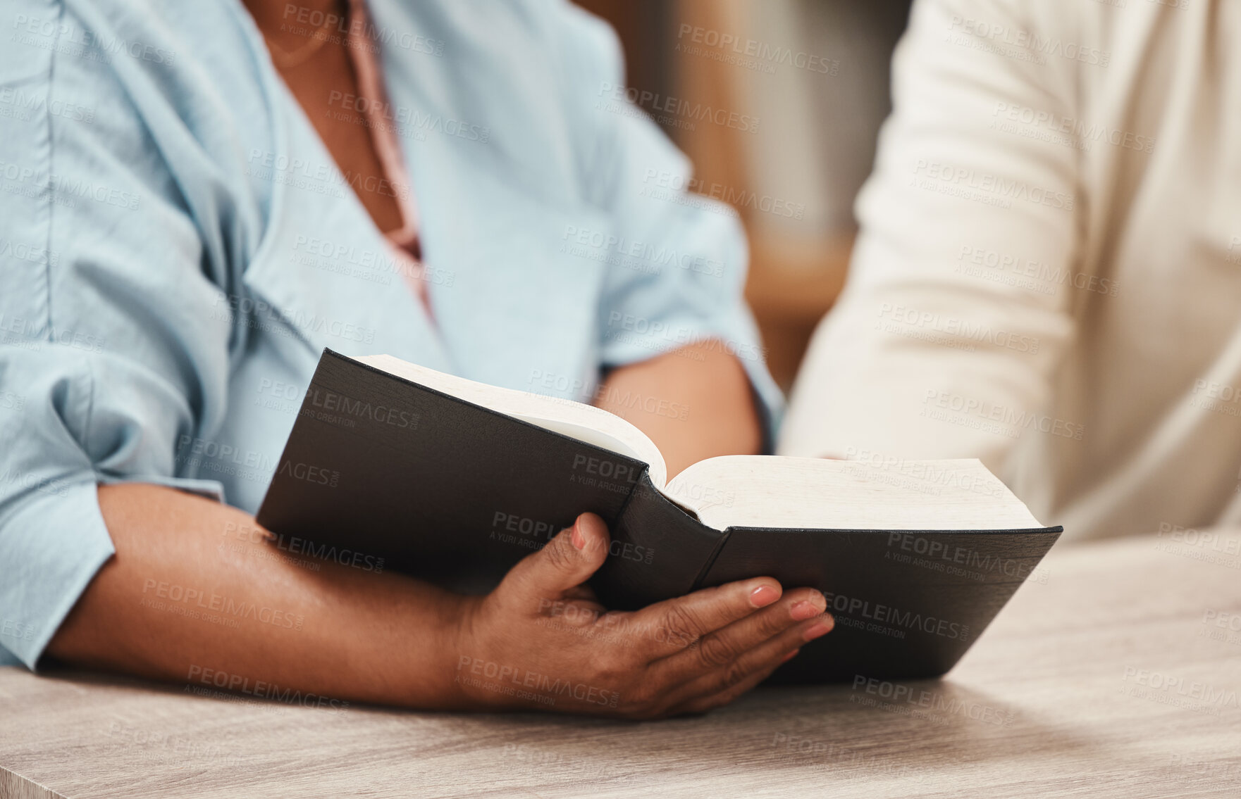 Buy stock photo Hands, bible and books with a senior couple reading a book together in their home during retirement. Jesus, faith or belief with a man and woman praying to god in their house for spiritual bonding