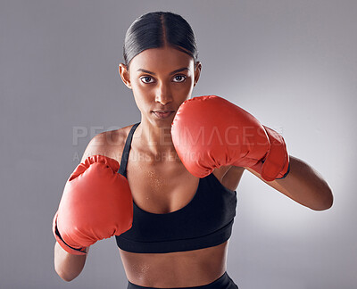 Buy stock photo Boxer, fight and portrait of woman in studio for sports exercise, strong muscle or mma training. Indian female, boxing workout and fist gloves for impact, energy and warrior power in battle challenge