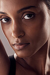 Portrait, skin and beauty with a model indian woman in studio on a gray background closeup for cosmetics. Face, skincare and eyes with an attractive young female posing indoor for natural dermatology