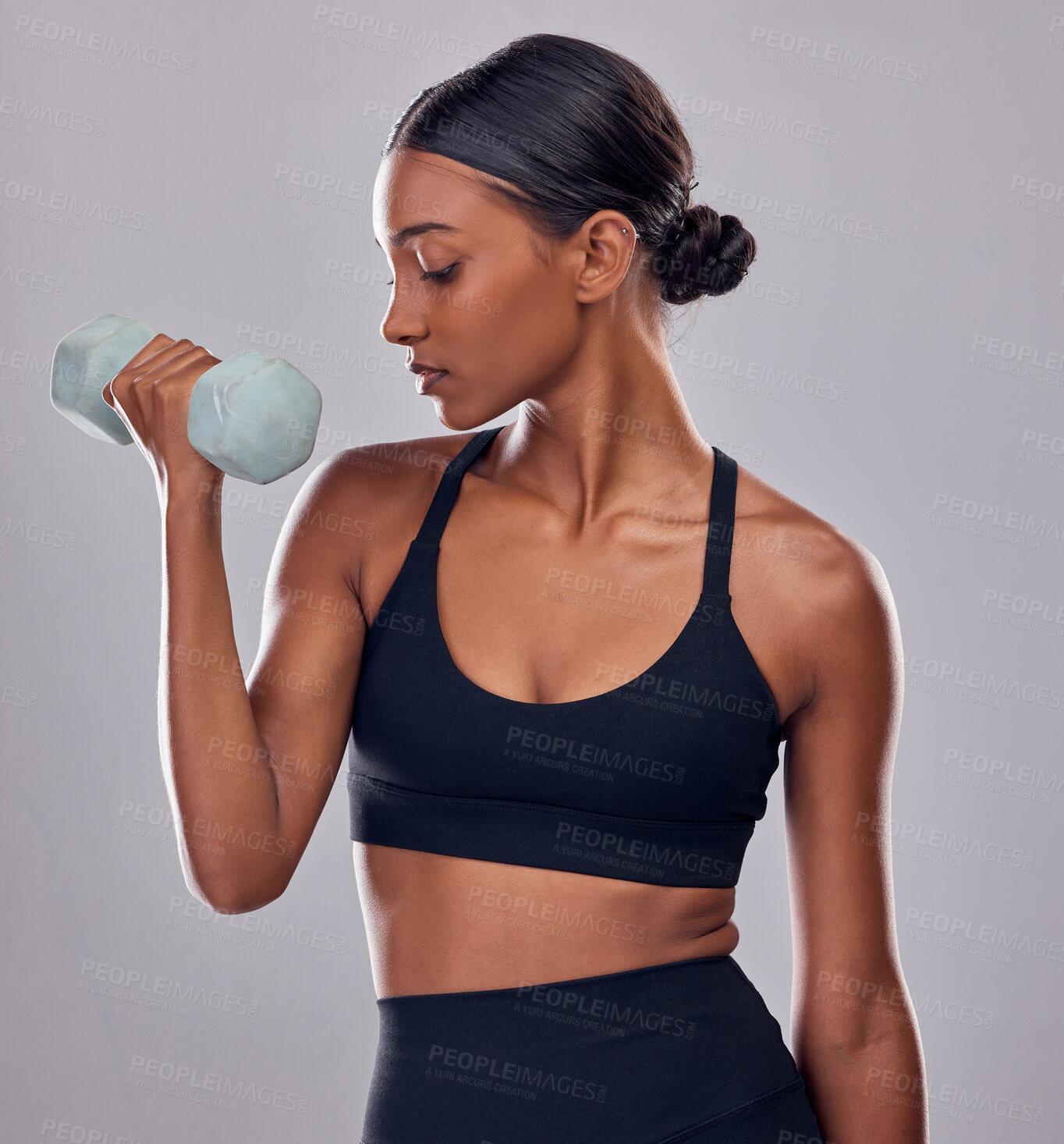 Buy stock photo Black woman, dumbbells exercise and studio for muscle development, wellness and self care with focus. Gen z bodybuilder girl, training and strong healthy body with gym equipment by gray background