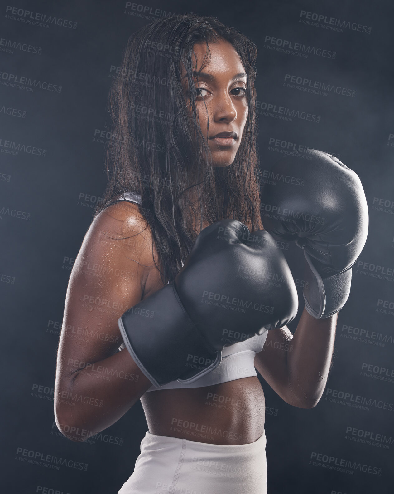 Buy stock photo Boxer gloves, woman and portrait on black background for sports, strong focus or mma training. Female boxing, champion and fist fight in studio, impact and warrior energy for power of fitness workout