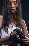 Boxer, gloves and sweat with a sports woman getting ready in studio on a black background for fitness. Exercise, health and training with a female boxing athlete sweating during a combat workout