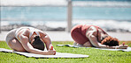 Woman, yoga friends and stretching on grass for wellness, strong legs and body in morning sunshine by sea. Women teamwork, fitness and workout by ocean with support, focus and mindfulness in summer